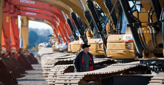 A registered bidder inspecting hydraulic excavators before the auction
